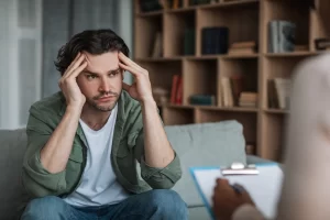 Man discussing his CBT thought records with a therapist to reframe stressful thinking patterns