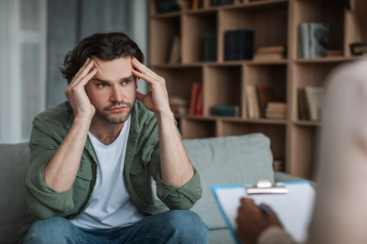 Man discussing his CBT thought records with a therapist to reframe stressful thinking patterns