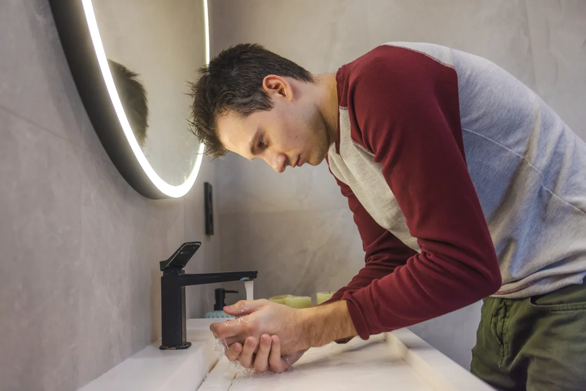 Anxious man washing his hands again, illustrating the line between OCD and being careful