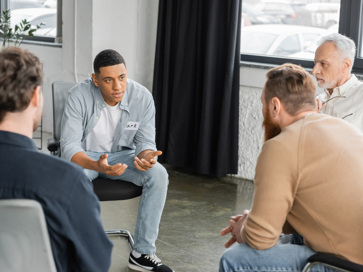 Person sitting quietly in a bright group therapy room during their first week in a partial hospitalization program